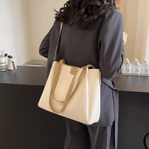Dettaglio della borsa tote off-white con spalline marroni e fibbia in pelle al caffè