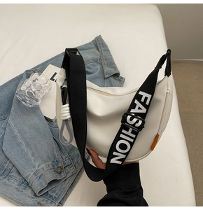 Nahaufnahme einer weißen Nylon-Sichel-Tasche mit einem breiten Fashion-Canvas-Gurt