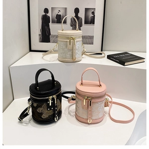 Detailed view of three cylindrical bucket bags featuring elegant floral and butterfly embroidery