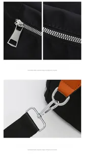 Detail of smooth metal zipper and detachable strap hook on black nylon travel bag