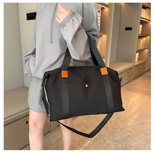 Detail view of large Oxford fabric travel bag with leather accents and shoulder strap