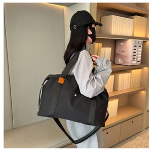 Large capacity black travel bag in water-repellent nylon with leather handle details