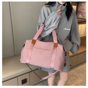 Detail of pink waterproof nylon travel bag with reinforced handles and removable shoulder strap