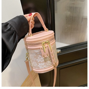 Detailed shot of a pink cylindrical bucket bag featuring floral embroidery and gold hardware
