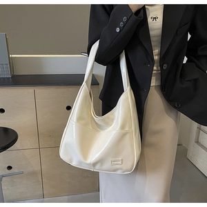 Close-up of cream leather tote bag featuring glossy finish and fashion label detail