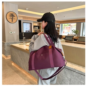 Detail of purple large capacity nylon travel bag with adjustable strap and metal hardware