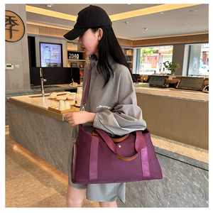 Detail of purple Oxford fabric travel bag with leather handles and side shoe compartment