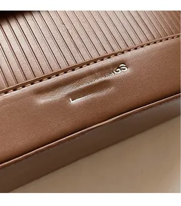 Macro shot of brown leather bag showing vertical embossed texture and white text details