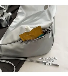 Detailed view of silver metallic bag side pocket with hidden zipper and spacious storage