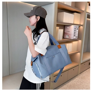 Crossbody view of a large blue oxford travel bag with high-density waterproof fabric