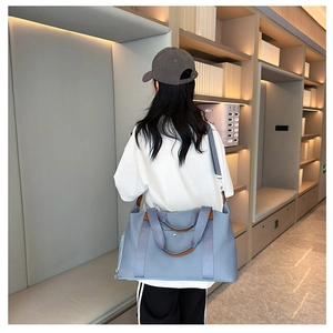 Rear view of the grey-blue Oxford cloth travel bag with contrast faux leather trim detail