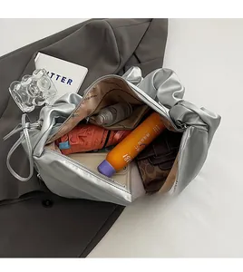 Interior view of large capacity silver pleated shoulder bag showing organized daily items