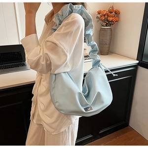 Détail du sac hobo plissé bleu clair avec large bandoulière et plaque en métal argenté