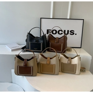 Detail showing five colors of leather bucket bags with wide jacquard straps and stitching