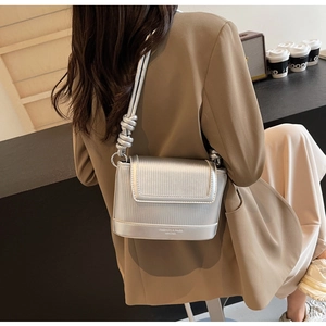 Silver pleated leather shoulder bag with thick twisted strap and metallic finish texture