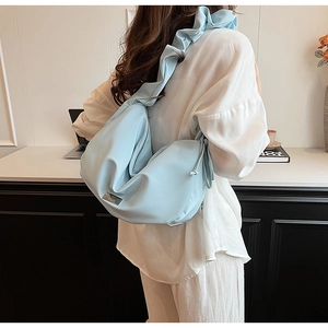 Détail du sac à bandoulière plissé bleu clair avec sangle à volants et fermeture éclair