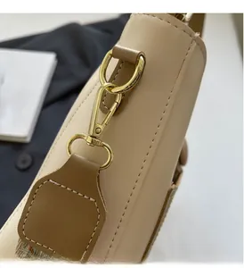 Close-up of golden metal hooks and stitching details on a minimalist bucket bag