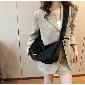 Vue détaillée du sac croissant en nylon noir avec logo argenté porté par un mannequin