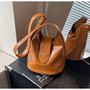 Caramel PU leather bucket bag with silver bow accent and adjustable shoulder strap
