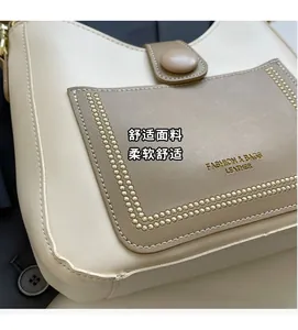 Detailed close-up of stitching, pebble texture and gold text on a two-tone bucket bag