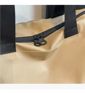 Close-up of khaki fitness bag featuring a smooth double zipper and durable black straps