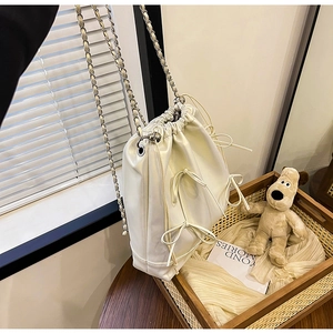 Dettaglio della borsa a secchiello bianco crema con chiusura a coulisse e fiocco