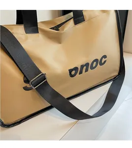 Detail of khaki travel bag showing adjustable black shoulder strap and smooth fabric