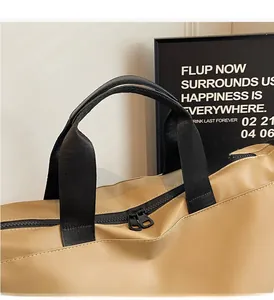 Detail of durable black wide handles and high-quality dual zipper on khaki travel bag