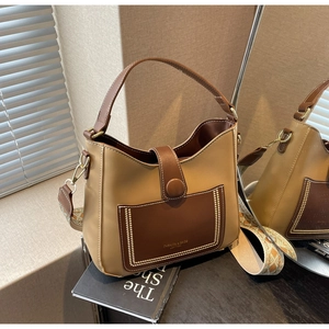 Detail of vintage bucket bag with contrast stitching and ethnic pattern wide strap