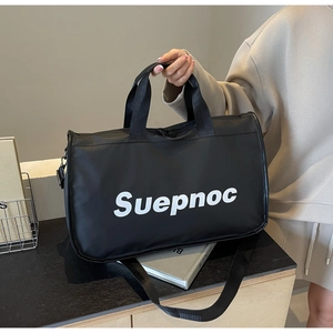 Detail of black travel bag with white Suepnoc print, sturdy handles and shoulder strap