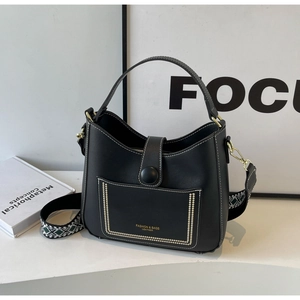 Detail of black leather bucket bag with white stitching and stylish patterned wide strap