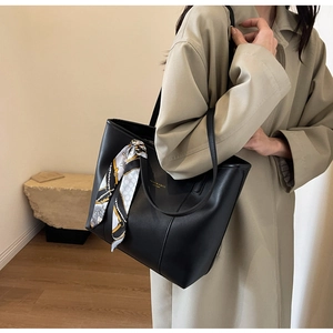 Black leather tote bag with printed silk scarf detail and golden logo branding
