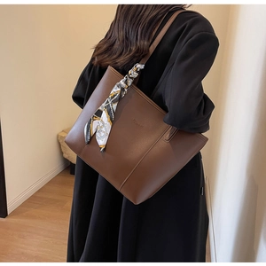 Brown leather tote bag with nautical silk scarf shown on model with black coat