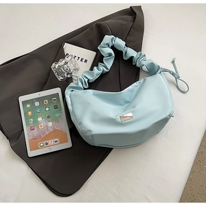 Détail du sac dumpling plissé bleu clair avec logo argenté et cordon de serrage latéral