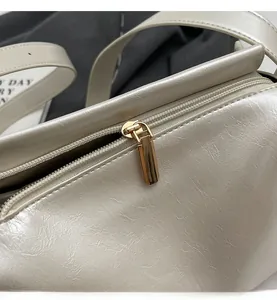 Vue macro de la fermeture éclair dorée lisse et du grain de cuir du sac oreiller crème