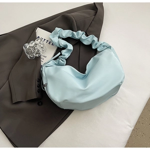 Détail du sac croissant bleu clair plissé avec bandoulière froncée et fermeture zippée métal