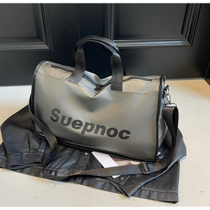 Detail of grey waterproof nylon gym bag with Suepnoc logo on black leather surface