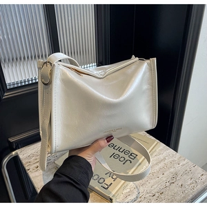 Gros plan sur le sac porté épaule en cuir blanc brillant avec texture froissée vintage