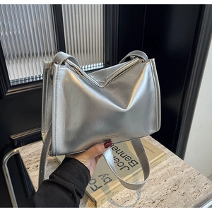 Détails du sac à bandoulière argenté métallisé avec lettrage mode et fermeture éclair