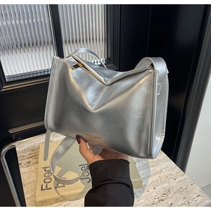 Détail de la texture cuir argenté métallisé et de la bandoulière sur un sac polochon chic