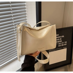 Détail d'un sac à bandoulière en cuir verni blanc crème avec sangle réglable et boucle en métal