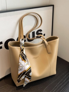 Minimalist khaki leather tote bag with elegant silk scarf wrap and fashion typography