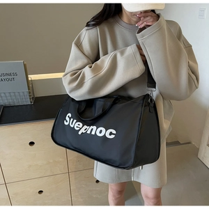 Black nylon travel bag with Suepnoc print, showing shoulder strap and handle details