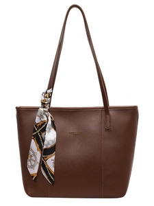 Brown leather tote bag with decorative silk scarf and spacious commuter shoulder design