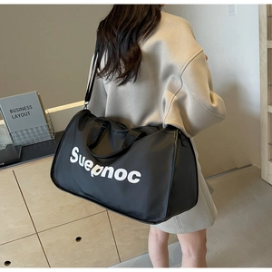Black large capacity travel bag side view showing white Suepnoc print and shoulder strap