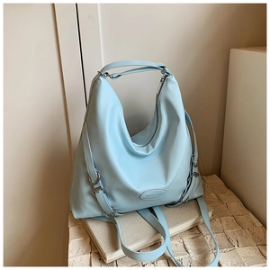 Dettaglio borsa tote azzurra in ecopelle con logo in rilievo e tracolla regolabile fornita