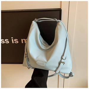 Dettaglio della borsa tote azzurra con logo in rilievo e fibbia metallica argento lucida