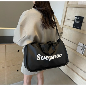 Rear view of a large black travel tote with white Suepnoc text and adjustable strap
