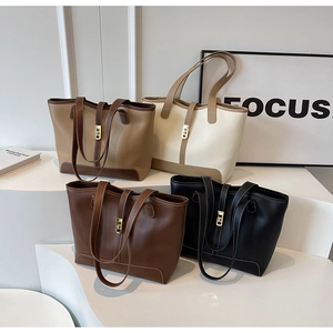 Detail view of large leather tote bags in four colors with gold metal twist locks