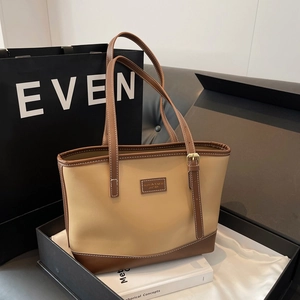 Detail of color-block tote bag in beige and dark brown with premium gift box packaging